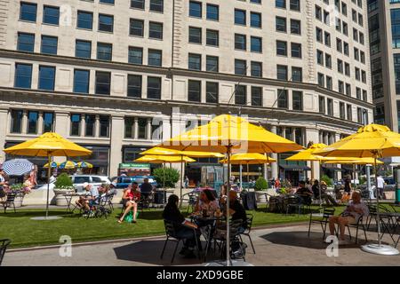 L'area pubblica con posti a sedere a Fifth Avenue e 23rd St. Presenta ombrelli gialli luminosi per ombra, 2024, New York City, Nomad, Stati Uniti Foto Stock