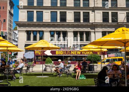 L'area pubblica con posti a sedere a Fifth Avenue e 23rd St. Presenta ombrelli gialli luminosi per ombra, 2024, New York City, Nomad, Stati Uniti Foto Stock