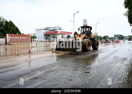 Huangshan, la provincia cinese di Anhui. 21 giugno 2024. Un bulldozer ripulisce il fango su una strada nella contea di Shexian, nella provincia di Anhui, nella Cina orientale, il 21 giugno 2024. Le piogge continue hanno colpito molte parti della Cina orientale e meridionale, causando vite umane, danneggiando le colture e tagliando le strade. Le autorità locali hanno aumentato i livelli di risposta alle emergenze per ridurre al minimo l'impatto delle condizioni meteorologiche estreme. Crediti: Huang Bohan/Xinhua/Alamy Live News Foto Stock