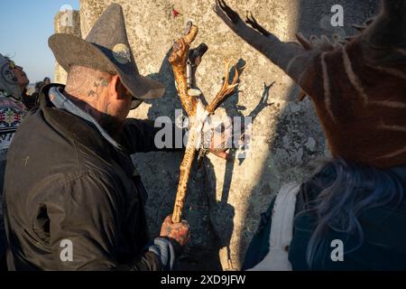 I festeggiatori spiritualmente celebrano il Solstizio d'estate (metà estate e giorno più lungo) tra le antiche pietre tardo-neolitiche di Stonehenge, il 21 giugno 2024, nel Wiltshire, in Inghilterra. Il solstizio d'estate è il giorno più lungo dell'emisfero settentrionale e la notte più breve dell'anno, quando l'asse terrestre è inclinato nel punto più vicino al sole e i pagani dicono che l'antico monumento è un luogo sacro che collega la Terra, la Luna, il Sole e le stagioni. Stonehenge è stata costruita in tre fasi tra il 3.000 a.C. e il 1.600 a.C. Stonehenge è di proprietà dell'English Heritage che dice che 15.000 visitatori sono stati ammessi Foto Stock