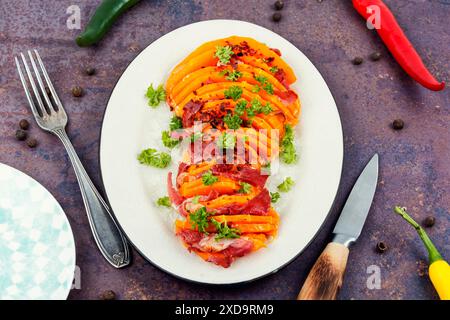 Piatto con zucca arrosto e pancetta. Zucca di butternut al forno con pancetta Foto Stock