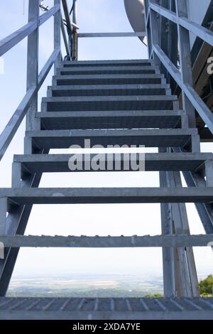 Scala in ferro per lavori di manutenzione. Struttura in acciaio e travi gli elementi strutturali contro il cielo blu dal punto di vista basso. Foto Stock