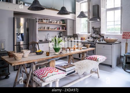 Antico cavalletto francese rustico con panca di olmo in cucina a doppia altezza nella scuola vittoriana del tardo XIX secolo, Battersea, Londra, Regno Unito Foto Stock