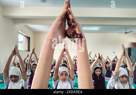 Mumbai, India. 21 giugno 2024. Gli studenti della scuola N.H.English Academy partecipano ad una sessione di yoga condotta in occasione della giornata Internazionale di Yoga. L'esecuzione di regolari esercizi di yoga offre vantaggi significativi nel ridurre lo stress, promuovere il benessere fisico e mentale che a sua volta porta gioia, felicità e tranquillità. Credito: SOPA Images Limited/Alamy Live News Foto Stock