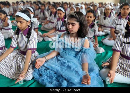 Mumbai, India. 21 giugno 2024. Gli studenti della scuola della N.H.English Academy meditano durante una sessione di yoga condotta in occasione della giornata Internazionale di Yoga. L'esecuzione di regolari esercizi di yoga offre vantaggi significativi nel ridurre lo stress, promuovere il benessere fisico e mentale che a sua volta porta gioia, felicità e tranquillità. Credito: SOPA Images Limited/Alamy Live News Foto Stock