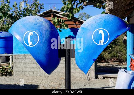 Cuba, Cuba, America centrale, due telefoni pubblici blu con il simbolo del telefono, ambiente rustico sullo sfondo Foto Stock