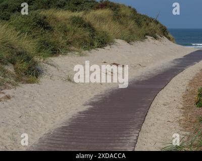 Una passerella in legno si snoda attraverso le dune sabbiose con vista sul mare, Juist, Frisia Orientale, Germania Foto Stock