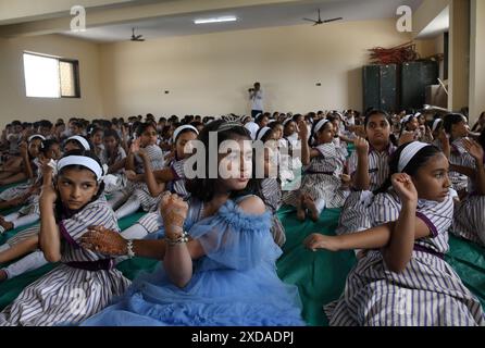 Mumbai, India. 21 giugno 2024. Gli studenti della scuola della N.H.English Academy si allungano durante una sessione di yoga condotta in occasione della giornata Internazionale di Yoga. L'esecuzione di regolari esercizi di yoga offre vantaggi significativi nel ridurre lo stress, promuovere il benessere fisico e mentale che a sua volta porta gioia, felicità e tranquillità. (Foto di Ashish Vaishnav/SOPA Images/Sipa USA) credito: SIPA USA/Alamy Live News Foto Stock