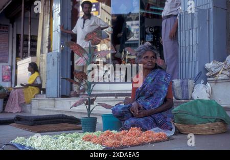 Una donna vende fiori in un mercato di strada e vicolo nella città di Chennai nella provincia Tamil Nadu in India. India, Chennai, aprile 1998 Foto Stock