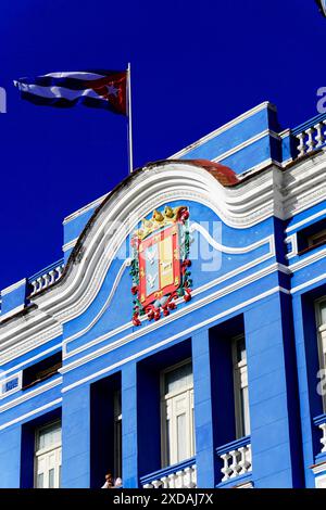 Città vecchia, Camagueey, Provincia di Camagueey, Cuba, America centrale, facciata superiore di un edificio storico blu con stemma e bandiera, più grande Foto Stock