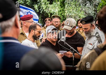 Oren Smadga, ( secondo da destra) padre del soldato caduto Omer Smadga, recita il Kaddish, la preghiera ebraica in lutto, durante il suo funerale al cimitero militare di Netanya venerdì 21 giugno 2024. Smadga è morto in combattimento con Hamas nella Striscia di Gaza giovedì. Suo padre, Oren, parlò sulla sua tomba e invitò l'IDF a continuare a combattere il più duramente possibile, 'sto dicendo ai soldati qui di tenere la testa alta. Continua ad andare il più duramente possibile. Non fermarti finché non vinciamo. Questo è il mio messaggio a chiunque combatta. AM Israel hai, Ó. Oren Smadga è la medaglia olimpica israeliana di judo dal Barcel Foto Stock