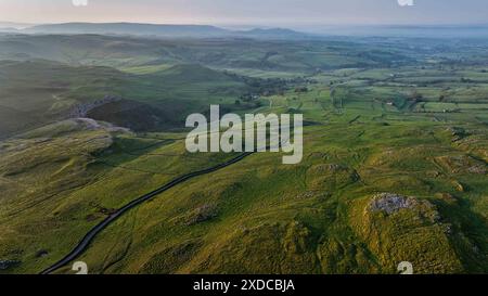 Questa immagine aerea mostra la campagna di Malham nelle valli dello Yorkshire mentre sorge il sole, illuminando il paesaggio vicino a Skipton Foto Stock