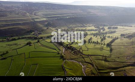 Questa immagine cattura una prospettiva aerea di Arncliffe, mostrando la lussureggiante campagna verde sullo sfondo di terreni accidentati, sottolineando il pittoresco paesaggio Foto Stock