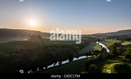 Una vista aerea mozzafiato di un'alba che getta luce dorata sul fiume e sul paesaggio della valle di Hawes, situato nelle Yorkshire Dales del Regno Unito Foto Stock