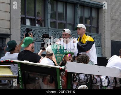 Boston, Massachusetts, USA 21 giugno 2024 Kristaps Porzingis (a sinistra) e Payton Pritchard nel Boston Celtics Rolling Rally per le strade di Boston per celebrare la vittoria dei Celtics alle finali NBA per la diciottesima volta. Oltre un milione di persone si sono allineate lungo il percorso della sfilata per esultare mentre i Celtici li hanno superati sulle Duck Boats. ( Rick Friedman ) Foto Stock