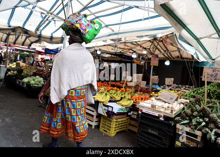 Donna che cammina attraverso il mercato di strada a Palermo, in Sicilia Foto Stock