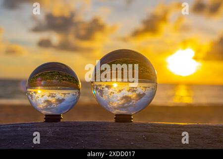 catturati con una sfera di cristallo per catturare il cielo colorato. tramonto mozzafiato sul mare al crepuscolo. Scena di luce arancione colorata al buio Foto Stock