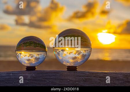 catturati con una sfera di cristallo per catturare il cielo colorato. tramonto mozzafiato sul mare al crepuscolo. Scena di luce arancione colorata al buio Foto Stock