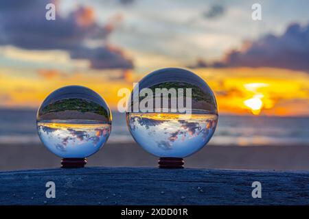 catturati con una sfera di cristallo per catturare il cielo colorato. tramonto mozzafiato sul mare al crepuscolo. Scena di luce arancione colorata al buio Foto Stock