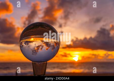 Questo time lapse è stato catturato con una sfera di cristallo per catturare il cielo colorato. tramonto mozzafiato sul mare al crepuscolo. Una scena di luce arancione colorata Foto Stock