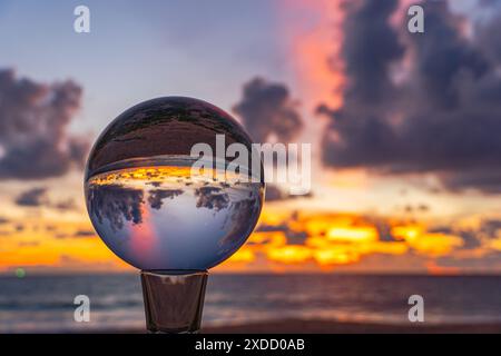 Questo time lapse è stato catturato con una sfera di cristallo per catturare il cielo colorato. tramonto mozzafiato sul mare al crepuscolo. Una scena di luce arancione colorata Foto Stock