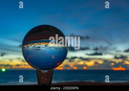 Questo time lapse è stato catturato con una sfera di cristallo per catturare il cielo colorato. tramonto mozzafiato sul mare al crepuscolo. Una scena di luce arancione colorata Foto Stock