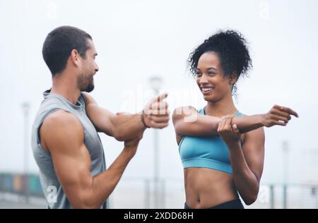 Coppia, braccia all'aperto e stretching per jogging, corridori e allenamenti sul lungomare per il fitness. Persone, supporto e flessibilità per muscoli o atleti per Foto Stock