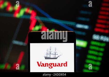 Cina. 21 giugno 2024. In questa immagine, il logo Vanguard della società di servizi di intermediazione americana di fondi comuni e ETF è stato visualizzato su uno smartphone con un grafico dell'indice di borsa economica sullo sfondo. (Foto di Budrul Chukrut/SOPA Images/Sipa USA) *** esclusivamente per notizie editoriali *** credito: SIPA USA/Alamy Live News Foto Stock