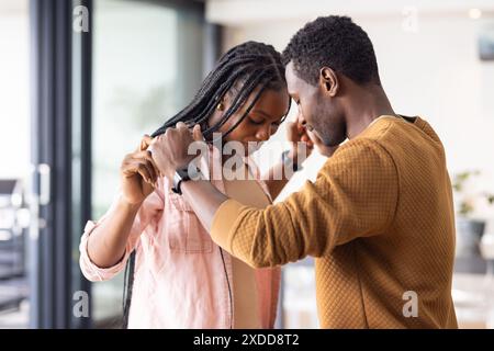 Giovane coppia che ballano insieme a casa, tenendosi per mano Foto Stock