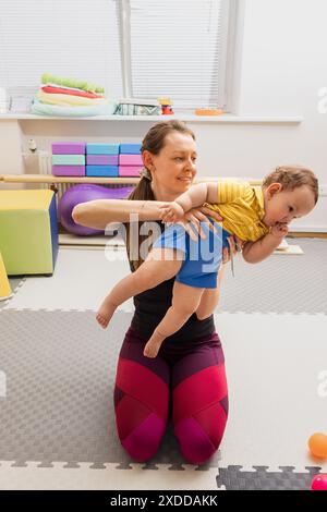 Fisioterapista che esegue l'esame neurologico infantile Hammersmith sul bambino nel centro di riabilitazione Foto Stock