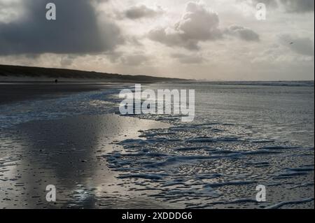 Nuvole che si riflettono in un residuo d'acqua sulla spiaggia vicino Egmond aan Zeen nel Nord Olanda, nei Paesi Bassi. Foto Stock