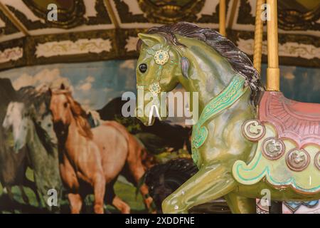 Carosello a cavallo in vecchio stile vittoriano d'epoca che sembra spaventoso nessuno nel parco divertimenti abbandonato. Foto Stock
