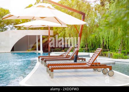 Lettini all'aperto vicino alla piscina, lettino da piscina, solarium presso l'area di svago dell'hotel. Foto Stock