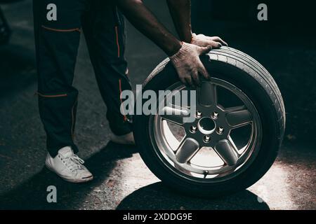 Il lavoratore dell'officina cambia le ruote gli pneumatici, l'assistenza professionale in officina Foto Stock