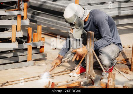 Pericolo a mani nude insicurezza lavoratore industriale scarso saldatore di metalli in cantiere Foto Stock