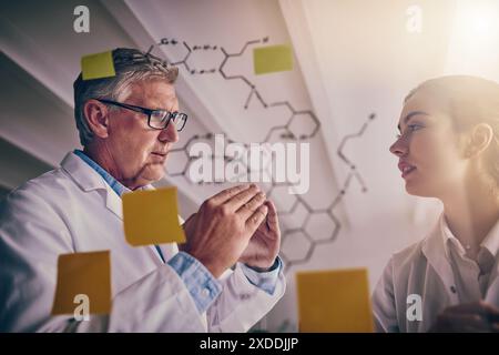 Scienziati, appunti e ricerca con pianificazione, soluzione e innovazione per esperimenti o molecole in laboratorio. Uomo, donna e parete di vetro con idee Foto Stock