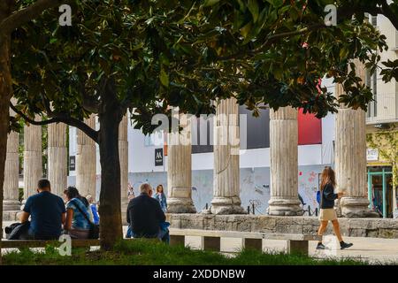 Turisti che riposano all'ombra di un albero di magnolia di fronte alle antiche colombe romane di San Lorenzo, quartiere porta Ticinese, Milano, Italia Foto Stock