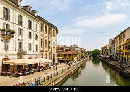 Vista sul corso d'acqua del Naviglio grande con persone in un ristorante all'aperto in primavera, Milano, Lombardia, Italia Foto Stock