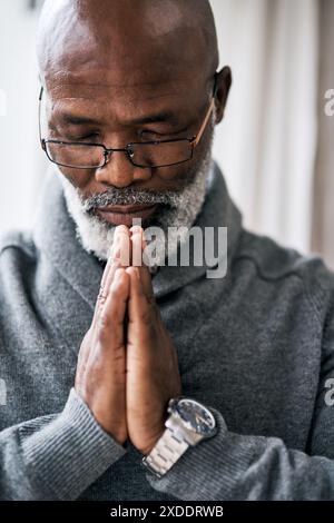 Pregare, mani e anziani neri in casa con pace, gratitudine e grazia, misericordia o fiducia in Dio. Adorazione, spiritualità e calma senior africana Foto Stock