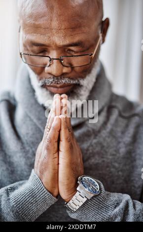 Pregare, mani e uomo nero anziano in casa con pace, gratitudine e grazia, misericordia o fiducia in Dio. Adorazione, spiritualità e calma anziani africani Foto Stock