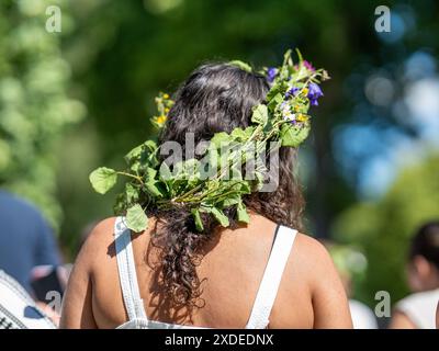 Spettatore femminile con corona di mezza estate durante la tradizionale celebrazione svedese di mezza estate a Söderköping, Svezia 2024 Foto Stock