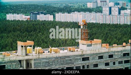 Construction Crane è coinvolta nella costruzione di Una nuova casa residenziale multipiano. Gru al lavoro. Costruzione e sviluppo di un nuovo multi Foto Stock