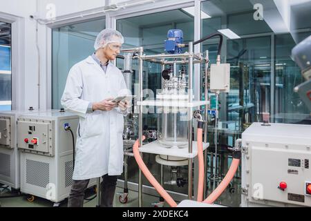 Personale scientifico che lavora con Equipment in Science Lab. Personale della fabbrica medica. Processi per impianti farmaceutici. Foto Stock