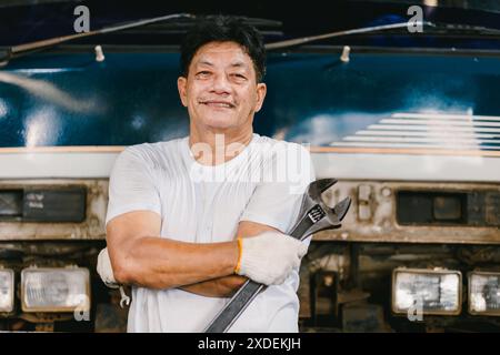 Meccanico automatico verticale che lavora nell'officina di assistenza Garage Car. Attraversamento sicuro del braccio di un operaio. Foto Stock