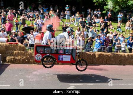 Alexandra Palace, Londra, Regno Unito. 22 giugno 2024. Bizzarri e stravaganti disegni di scatole di sapone hanno corso lungo il percorso collinare attraverso Alexandra Park sotto la Ally Pally e su salti che hanno testato i design e le abilità di guida delle squadre. Un gran numero di carrelli fatti a mano alimentati esclusivamente dalla gravità e una spinta degli equipaggi dalla cima della collina tentarono di stabilire il tempo più veloce. Molti sono venuti a soffrire prima del traguardo, che è stato subito dopo una rampa di salto che ha lanciato i carri più veloci in alto. Amici di squadra da fine Foto Stock