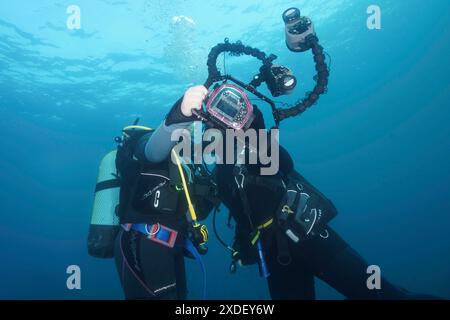 Due subacquei scattano una foto, un selfie, sott'acqua con una fotocamera. Sito di immersione riserva marina Cap de Creus, Rosas, Costa Brava, Spagna, Mar Mediterraneo Foto Stock