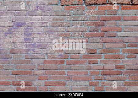 Vecchio muro in mattoni rossi con un sacco di texture e colori. Modello astratto di una vecchia parete di mattoni rossi, arancioni e neri, con molta consistenza utile per lo sfondo Foto Stock