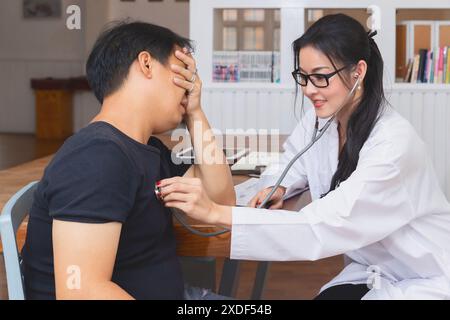 Medico che verifica il paziente con stetoscopio. Medico che ascolta il torace del paziente con stetoscopio nel suo ufficio in ospedale. Foto Stock