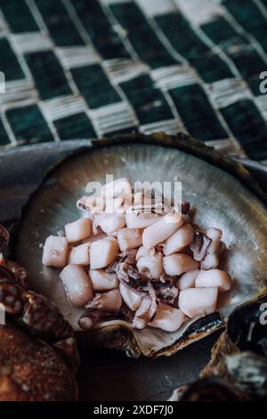 Un piatto di pesce fresco che include granchio, calamari, cozze e una prelibatezza locale alla Laguna di Detwah, Socotra, Yemen Foto Stock