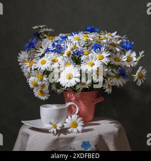 Bouquet di fiori estivi. Camomiles e cornflowers. Bianco e blu. Natura morta Foto Stock